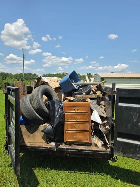 Dump trailer loaded with tires, furniture and household junk ready for haul-away