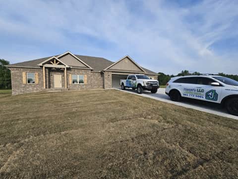 Xenya's LLC trucks parked at a residential job site in Central Arkansas