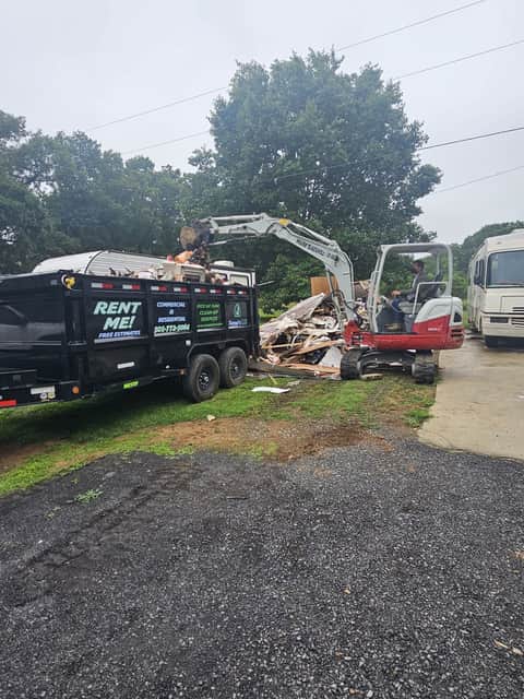 Excavator loading construction debris into the dump trailer