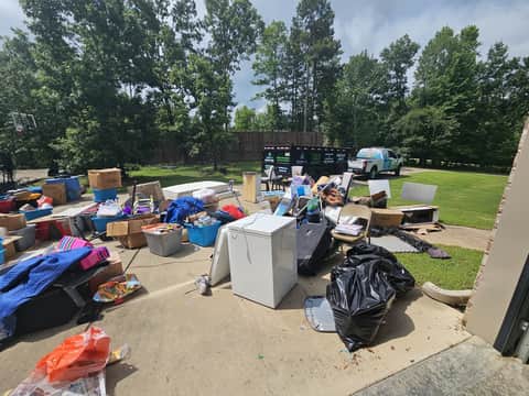 Driveway staged with furniture and appliances ready for haul-away
